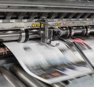 a close up of a newspaper being printed on a machine .