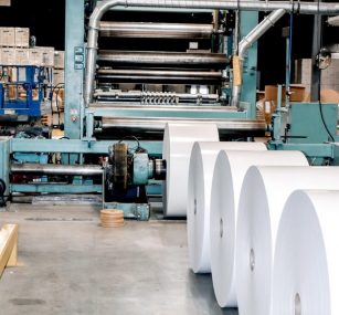 several rolls of paper are being made in a factory