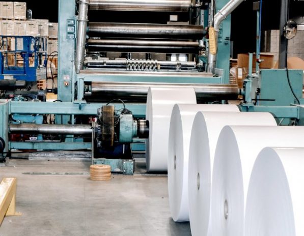 several rolls of paper are being made in a factory
