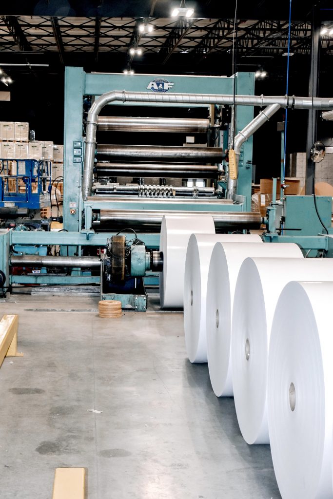several rolls of paper are being made in a factory