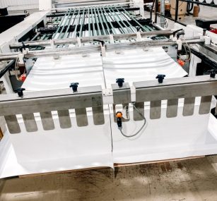 a sheeter min cutting a piece of paper in a factory .