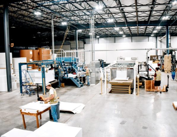 man in green vest working in sheeter side of warehouse