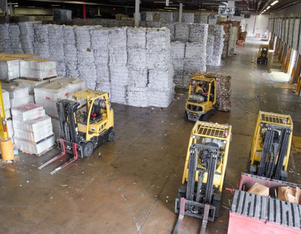 several forklifts are working in a large warehouse