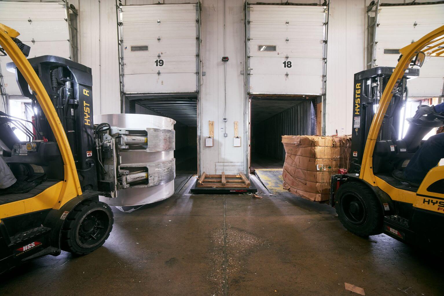 two hyster forklifts are in a warehouse